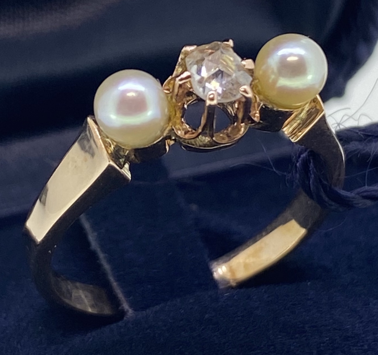 Anello di periodo con due perle e diamante centrale.